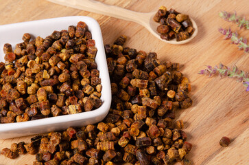 Bee bread heap in  bowl on table, alternative medicine