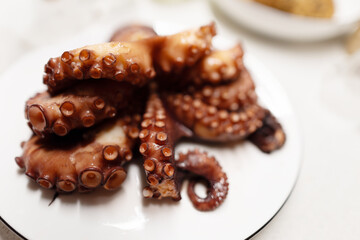 Boiled red octopus is taken out of the pan.