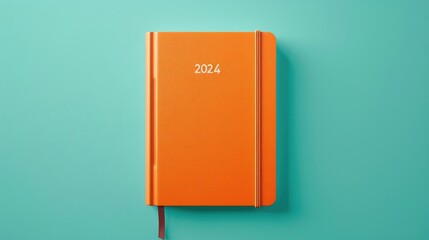 Orange diary for 2024 with artificial leather cover on a mint background. New Year concept in trendy colors
