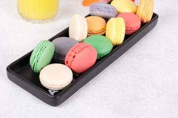 A Colorful Array of Macarons on a Black Plate: A Delightful and Vibrant Treat