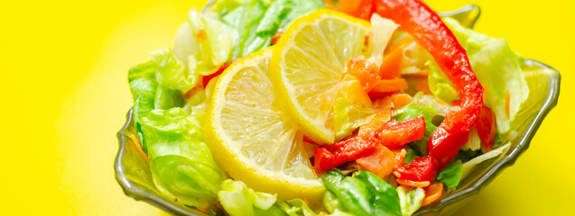A bowl of salad with a lemon slice on top