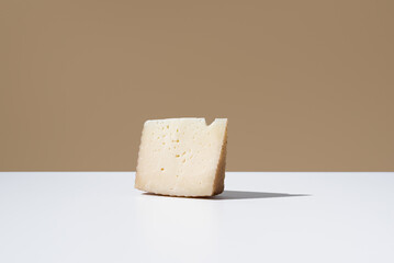 Trozo de queso de oveja curado. Queso manchego sobre fondo marrón
