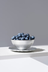 Ar&aacute;ndanos frescos en un recipiente sobre fondo gris	