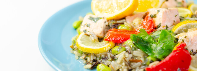 A plate of food with a piece of tuna and a lemon wedge