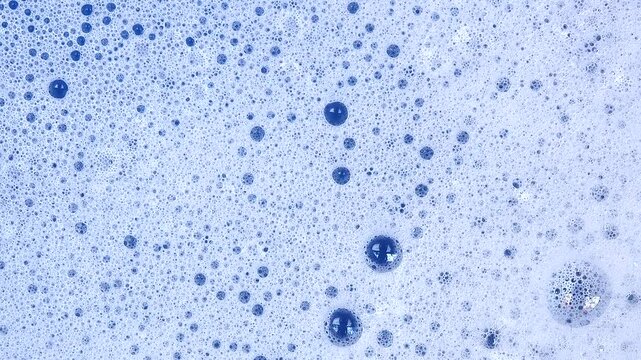 Soapy foam texture with bursting soap bubbles