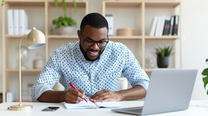 Obraz premium A smiling man enjoys a productive moment in his home office, writing notes with a red pen. His workspace is modern and well-arranged, perfect for focused work.