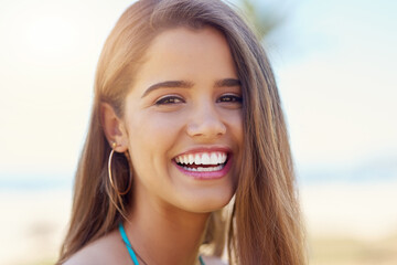 Summer, holiday and portrait of girl with laugh, travel or relax at beach for outdoor adventure. Happy, face and closeup of confident woman on tropical island for fun vacation in nature with blue sky