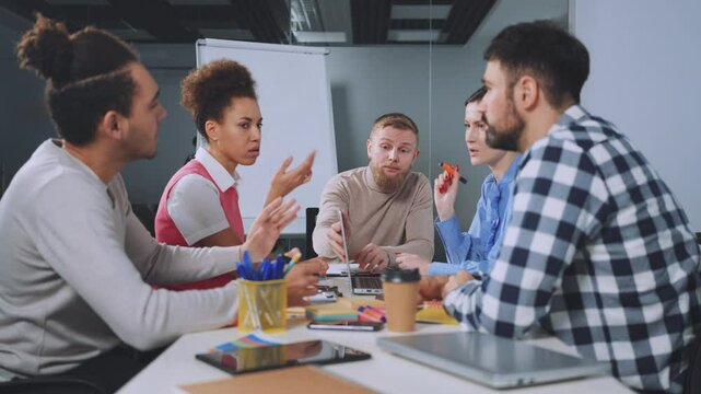 Team members argue, each defending their point of view during intense office meeting. Gestures and facial expressions convey passion and disagreement. Concept of workplace conflict and communication
