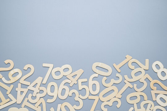 Many wooden numbers scattered at the bottom of gray background
