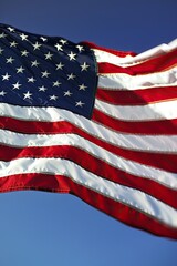 Obraz premium A detailed close-up of a worn American flag, with stars and stripes, illuminated by natural sunlight indoors..
