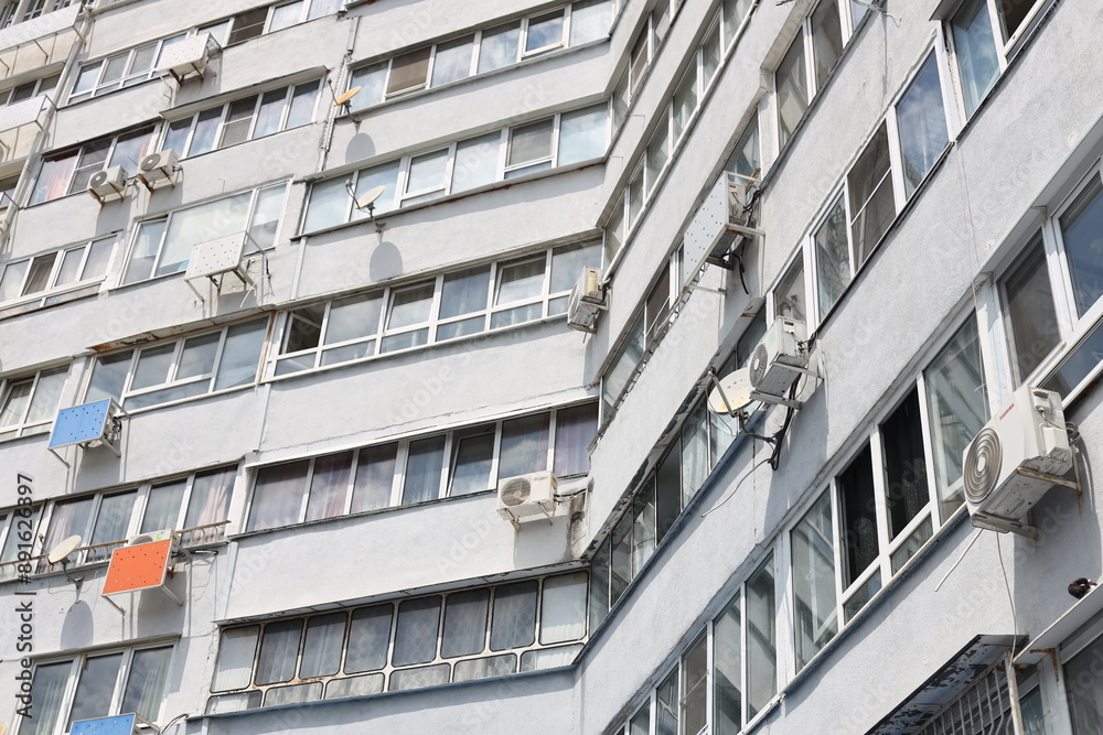 Poster a large building with multiple air conditioners installed on its exterior walls.