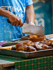 Man Cutting Pork Skin at a Street Food Stall