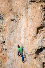 A rock climber climbs to the top along a difficult route.

