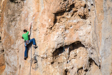 A rock climber climbs to the top along a difficult route.
