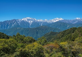 Fototapeta premium mountain range from an angle, clear blue sky, distant snow-capped mountains in background