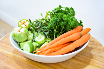 Healthy food: Fresh vegetables rosemary, carrots, brinjal and cucumber in a white ceramic plate.