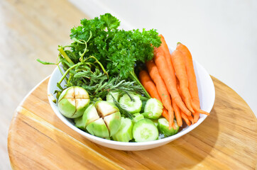Healthy food: Fresh vegetables rosemary, carrots, brinjal and cucumber in a white ceramic plate.