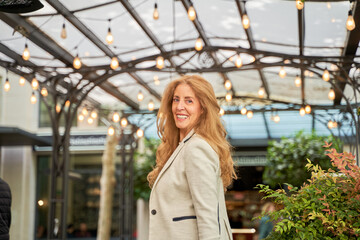 Fototapeta premium portrait of an elegant woman in a blazer looking at the camera over her shoulder
