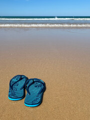 Blaue Flipflops am Strand