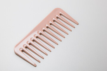 Closeup of pink wide-teeth comb isolated on white background