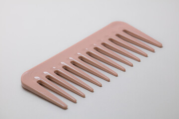 Closeup of pink wide-teeth comb isolated on white background