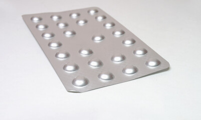 drug blister pack of hard aluminium foil. medicine packaging for small tablets. closeup