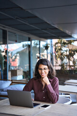 20s latin hispanic freelance business entrepreneur. Smiling businesswoman working remotely online on laptop computer outdoors. Smiling Indian young student woman using pc app for learning. Vertical