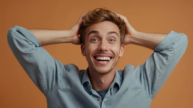 Man With Brown Hair and Blue Shirt Holding His Head in Excitement