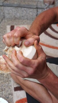 peels coconut with hands vertical video