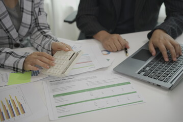 Two businessmen meeting to analyze financial reports with tablet on paper on table and analyze the power dashboard display. on your tablet screen for business insights