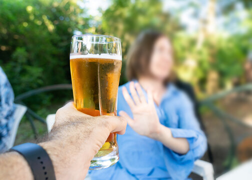 Reject a glass of beer, woman refusing alcohol, stop drinking, sobriety concept, saying no to beer glass
