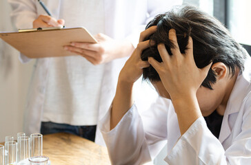 Young tired student taking online classes, he confused and stressed headaches for exams staring study online at the computer screen in classroom. Education test concept.