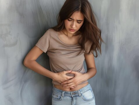 Uma mulher com express&atilde;o de dor devido a c&oacute;lica