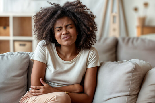 Uma mulher com express&atilde;o de dor devido a c&oacute;lica