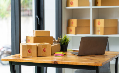 Small business startup, SME owner, Asian female entrepreneur working with boxes, parcels, writing delivery addresses. and check your orders online at