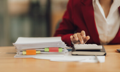 Business woman uses calculator to analyze finances