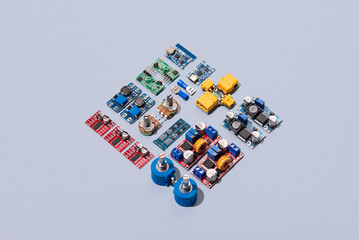 Microcontrollers, boards, sensors, leds and modules for learning the basics of electronics. Various electronic components for soldering arranged in creative arrangement