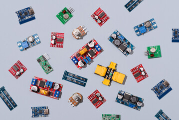 Microcontrollers, boards, sensors, leds and modules for learning the basics of electronics. Various electronic components for soldering arranged in creative arrangement