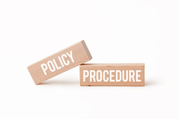 Two wooden blocks with 'policy' and 'procedure' written on them.