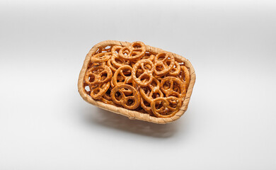 Basket full of pretzels isolated on white background. Golden brown pretzels stacked in a basket.