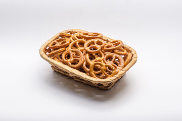 Basket full of pretzels isolated on white background. Golden brown pretzels stacked in a basket.