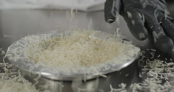 Turkish dessert kunefe or kunafa preparation. Close-up pastry chef pour kataifi dough in the copper plate with hands. Arabic sweets. Middle eastern traditional food dessert