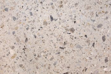 A white and gray stone surface with many small stones scattered across it. The surface appears to be a mosaic or a tiled floor