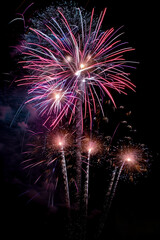 Abstract colorful firework against dark night bokeh blurry sky background. Happy New Year 2025 holiday celebration.