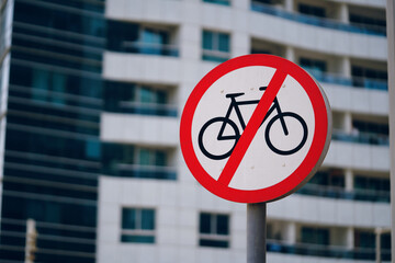 A traffic sign featuring a crossedout bicycle symbol is displayed in front of the building, indicating bicycles are not permitted on the premises