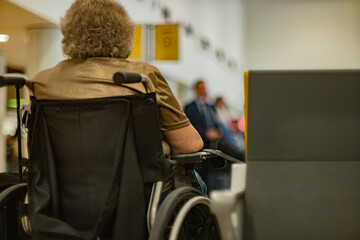 Anciana en silla de ruedas en un aeropuerto esperando por ayuda, concepto de cuidados al adulto...
