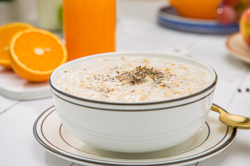 Oatmeal, healthy food item  arranged on wooden background in a ceramic bowl.