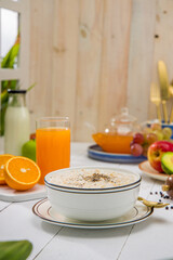 Oatmeal, healthy food item  arranged on wooden background in a ceramic bowl.