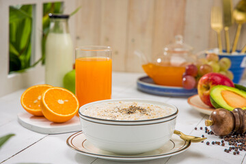 Oatmeal, healthy food item  arranged on wooden background in a ceramic bowl.