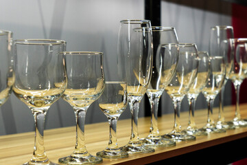 Elegant different wine and champagne glasses on a store shelf for sale. Shopping concept